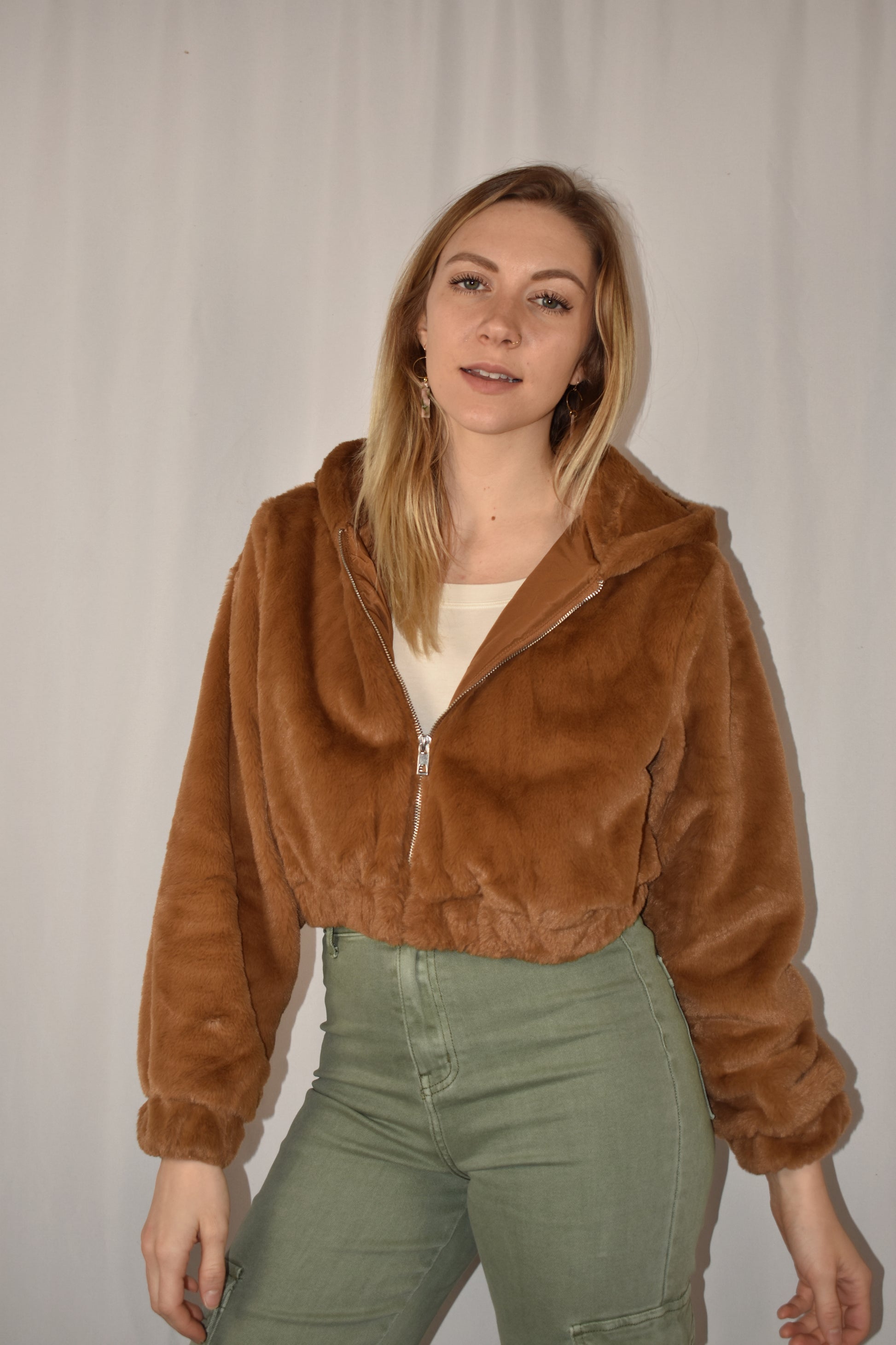 Super soft cropped faux fur zip front hoodie with side pockets and elastic hem.