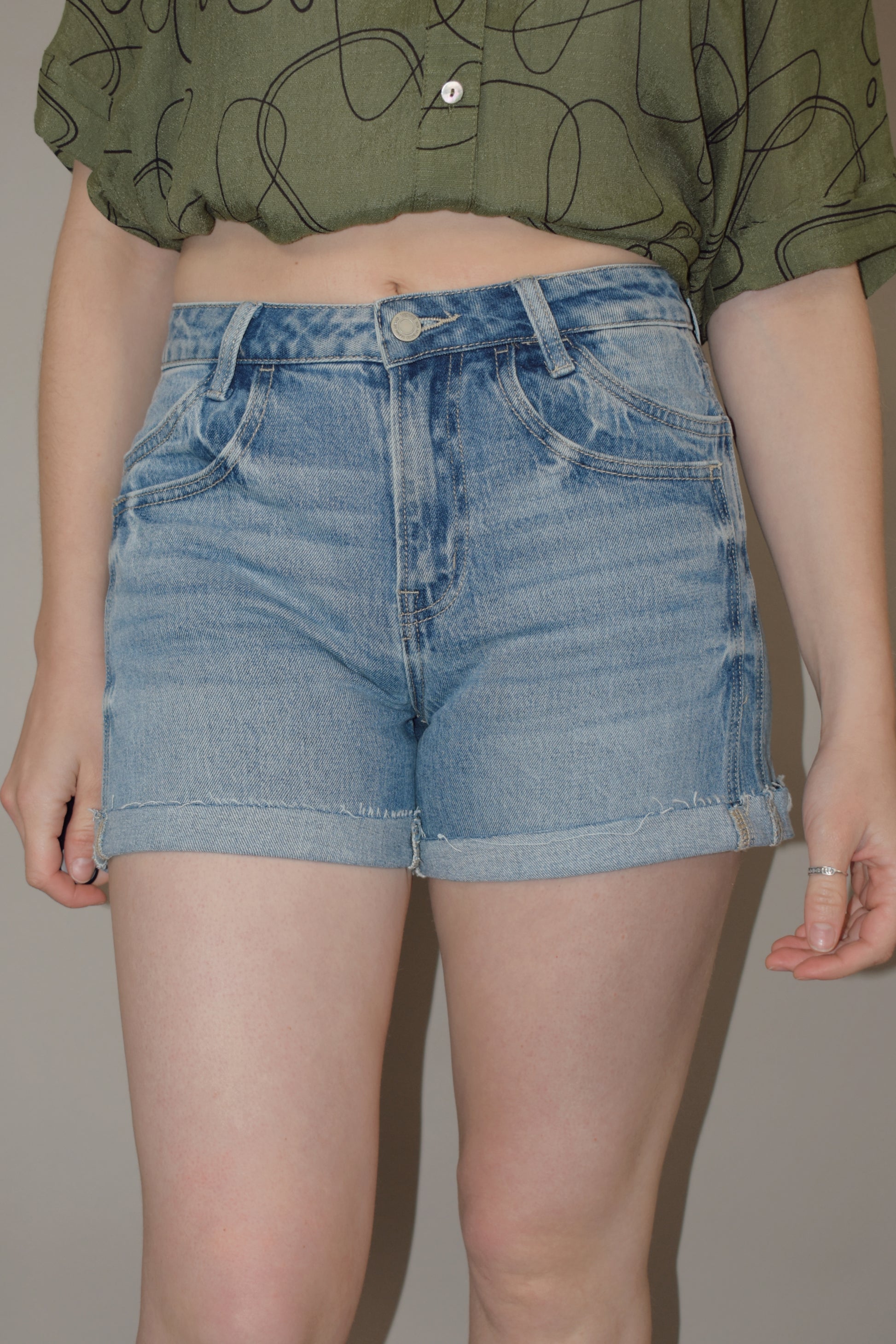 light wash cuffed denim shorts with a double pocket and seam detail, no holes, has a zip and button enclosure