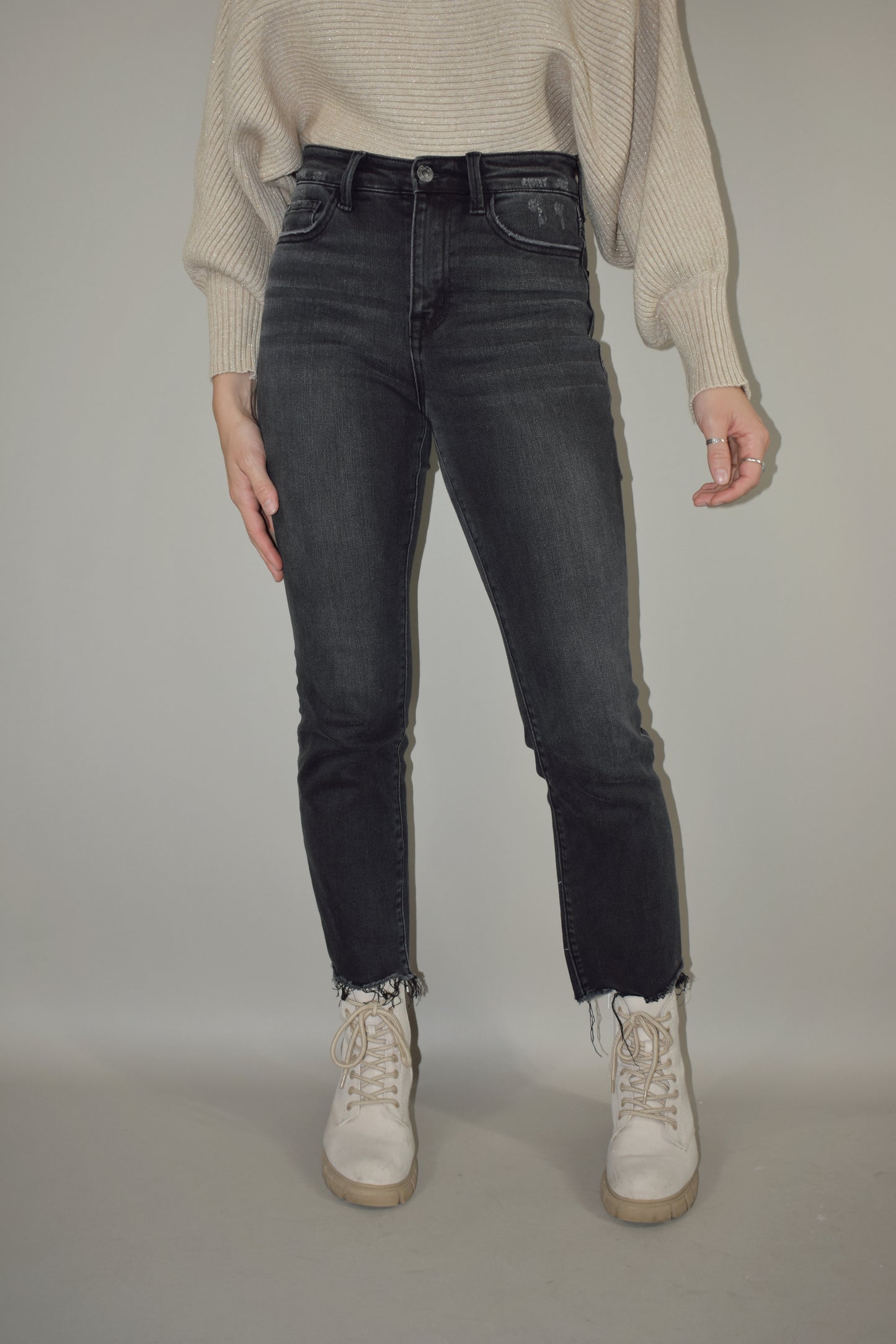 high waisted stretch washed black denim jeans cropped with uneven raw hem and has a straight fit with no holes