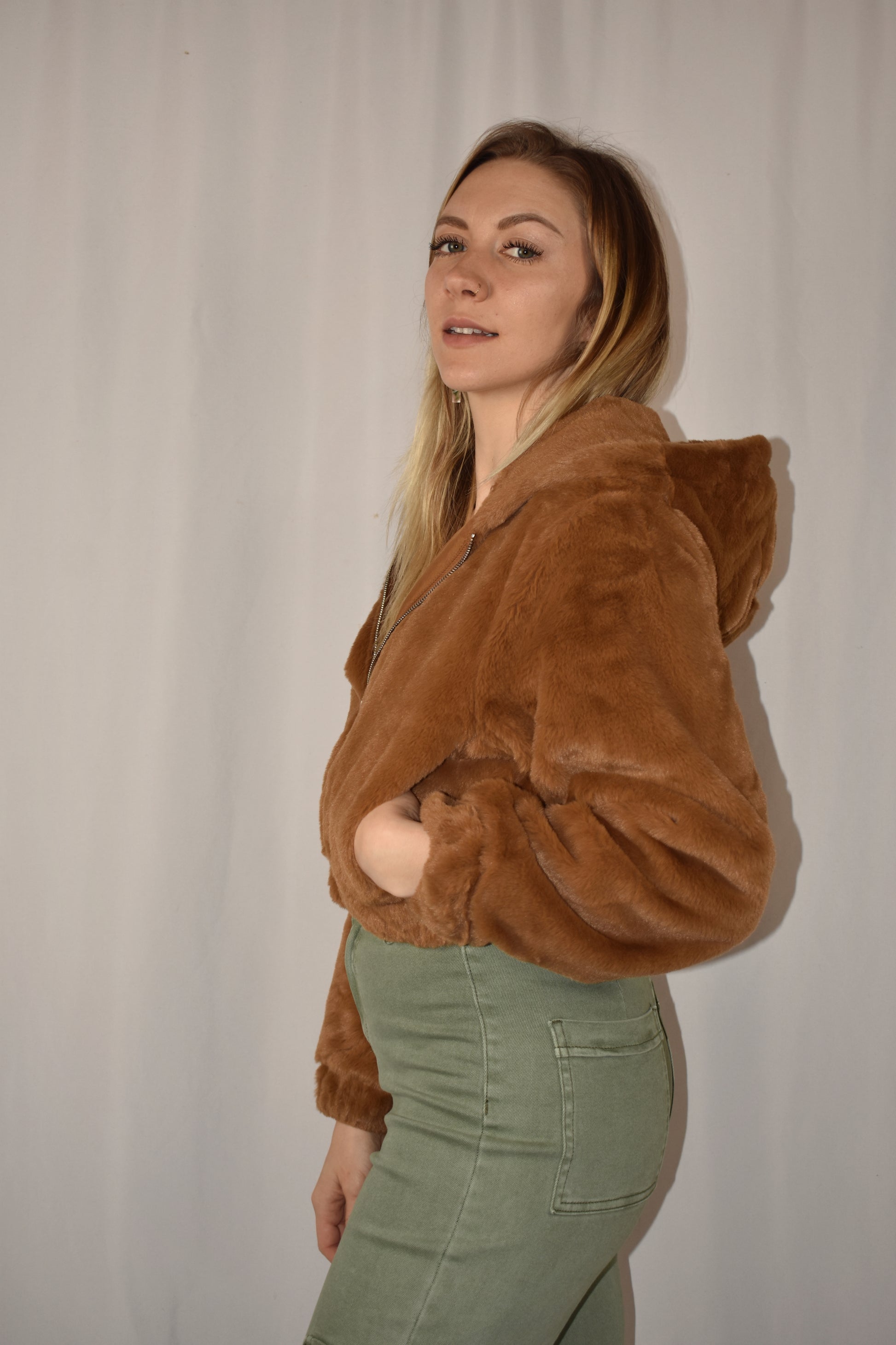 Super soft cropped faux fur zip front hoodie with side pockets and elastic hem.