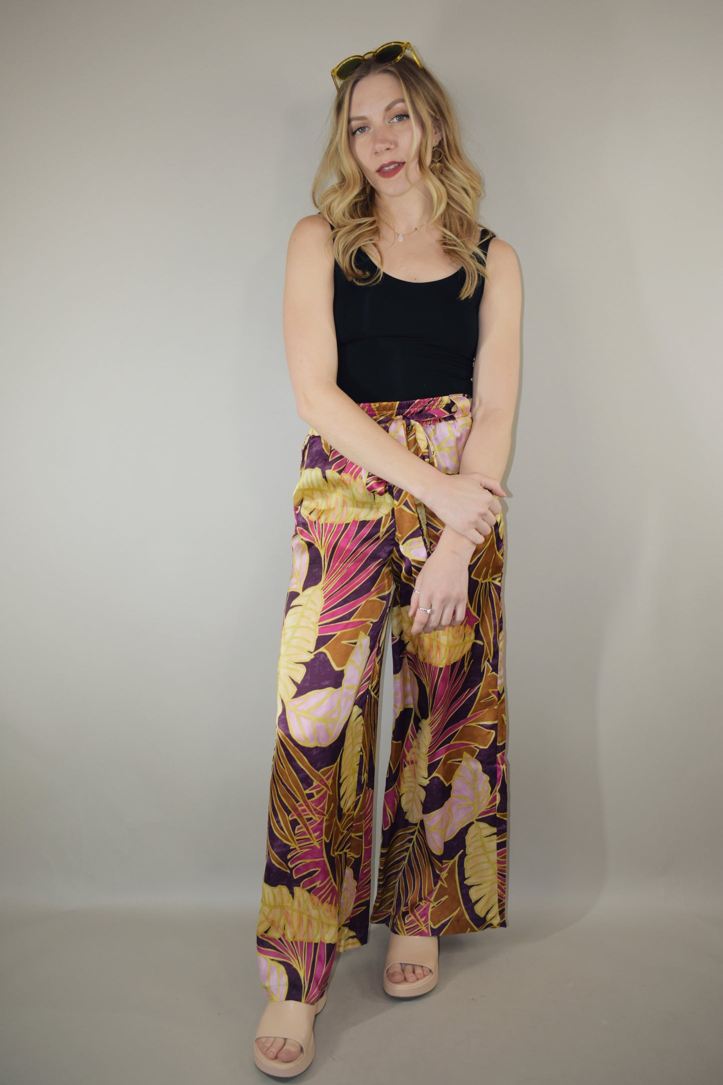 satin wide leg pants high waisted full length with elastic on back of waistband satin sash waist tie has beltloops and pockets tropical print with magenta cream and blush tones