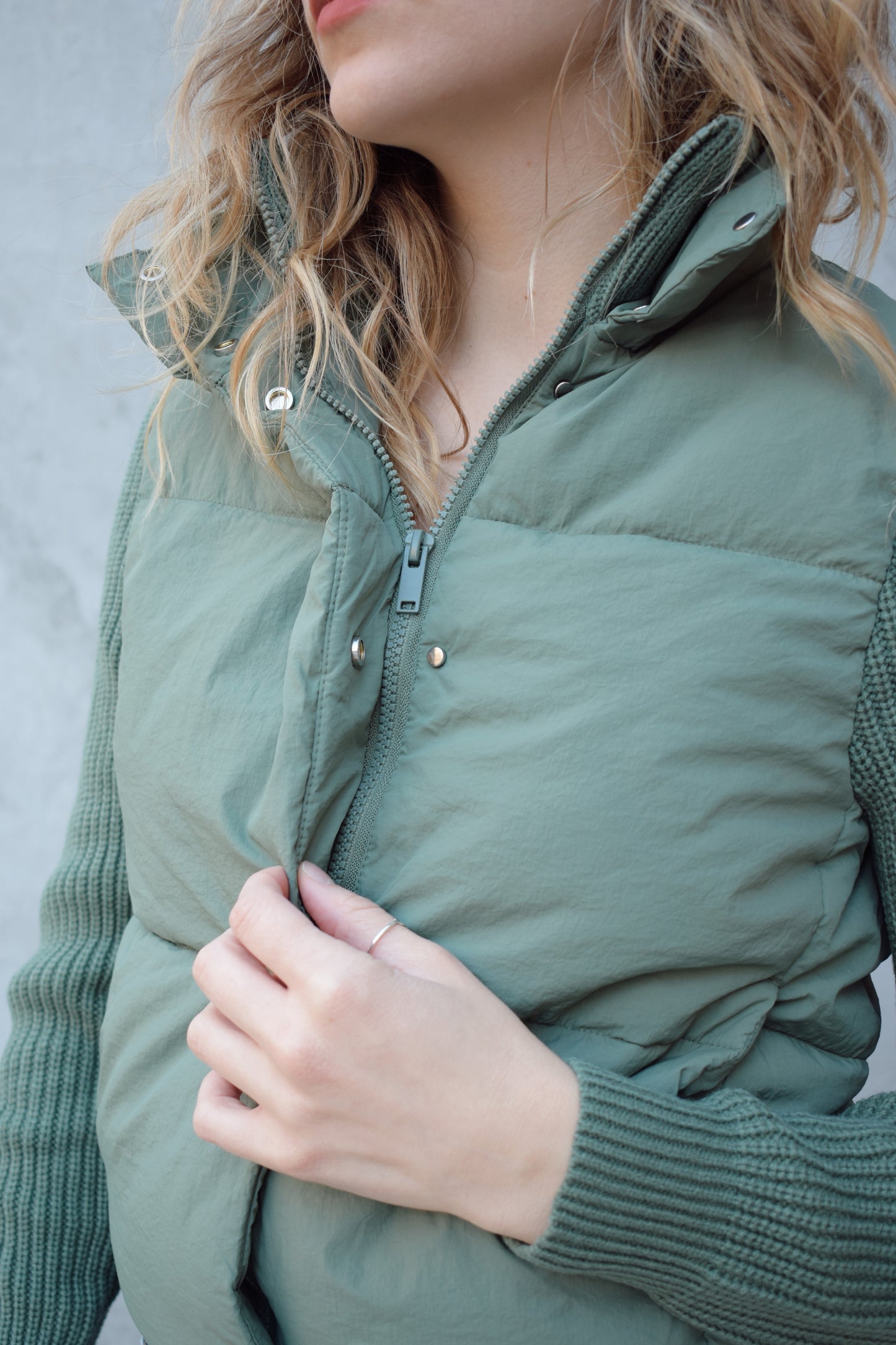 blue green puffer jacket with ribbed knit sleeves, zip and snap front enclosure, has double collar with both materials, has pockets, sinch band at hem