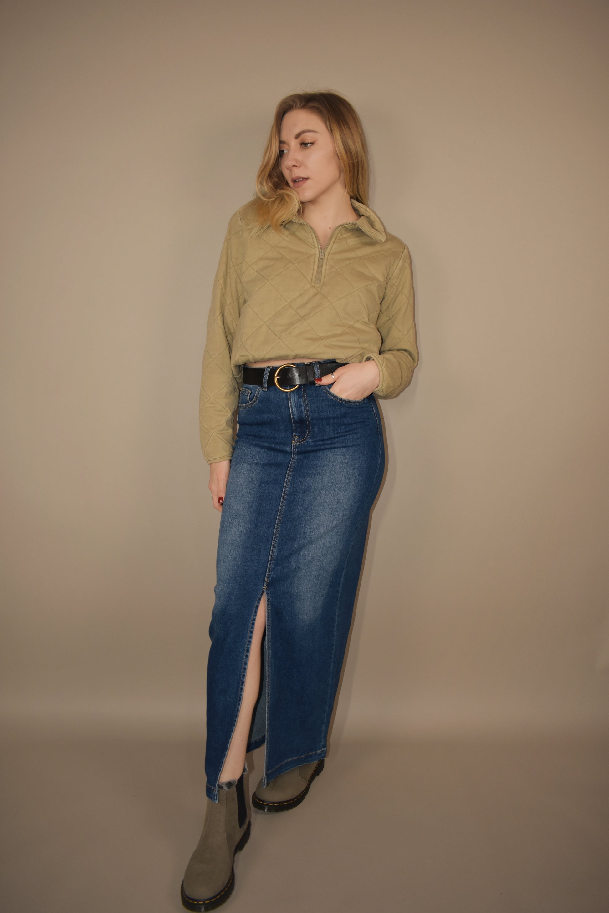 denim midi skirt that is more full length than midi and has a front slit with front and back pockets and is high waisted. made of stretch denim and is a medium dark wash.