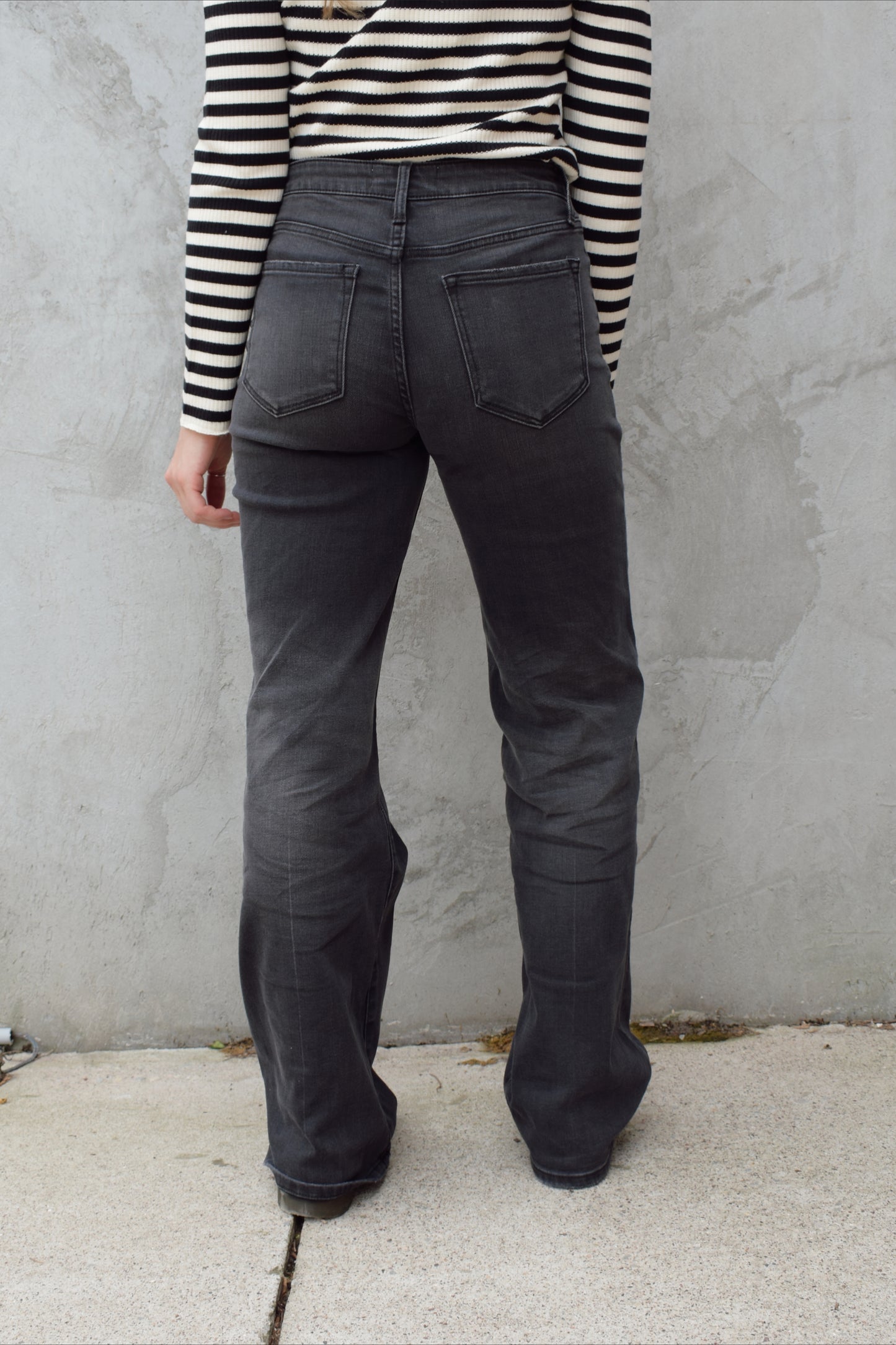 high rise washed black wide leg flare jeans full length stretch denim distressed hem but no holes zip and button enclosure has beltloops has front and back pockets 