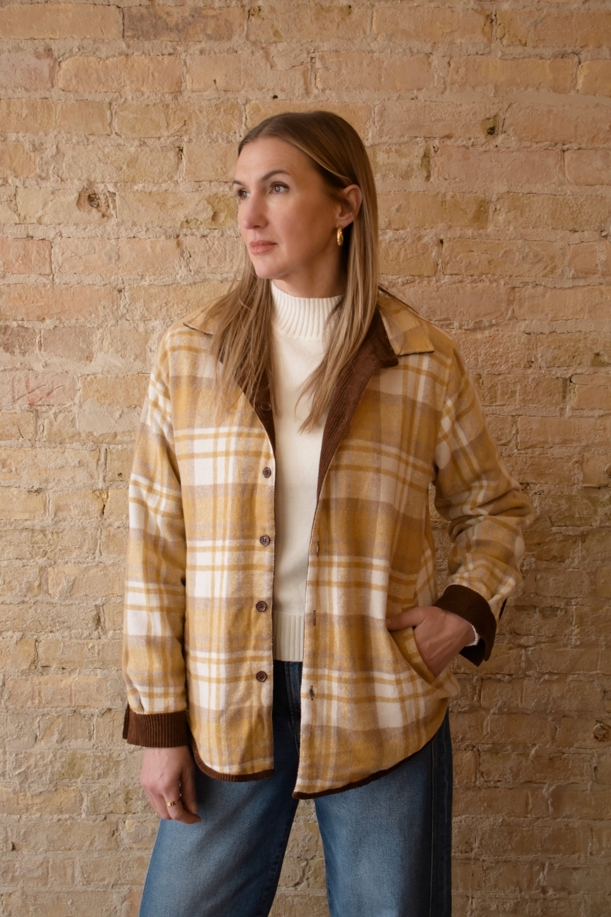 dark brown corduroy shacket lined with mustard color plaid flannel, reversible, one side has breast pockets the other has side front pockets, button down, relaxed fit full length
