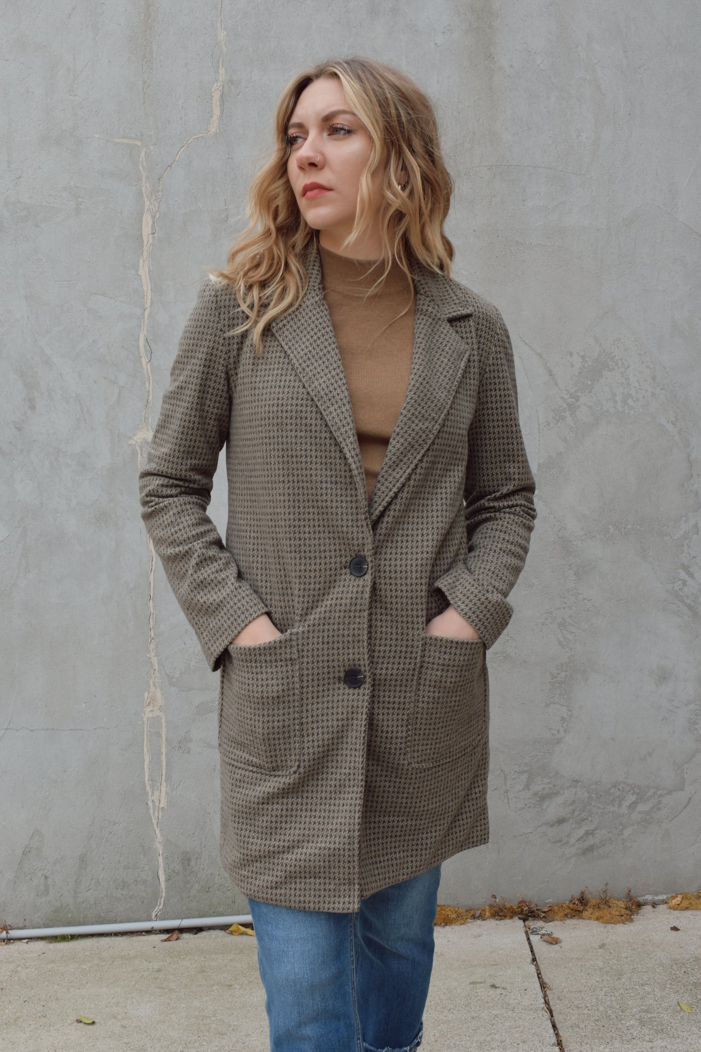 Houndstooth longline blazer, structured and fitted,  long sleeves, a notched collar, double button closure. patch pockets on front. hits above the knee.