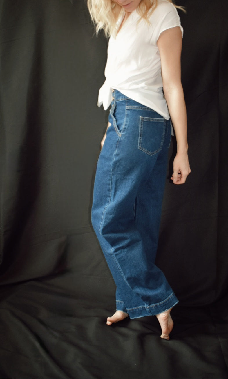 Q2. Relaxed high waist silhouette jeans with wide leg and straight fit. Gold sailor buttons on either side in the front. Dark blue. No holes no distressed wash. Made in Italy. 