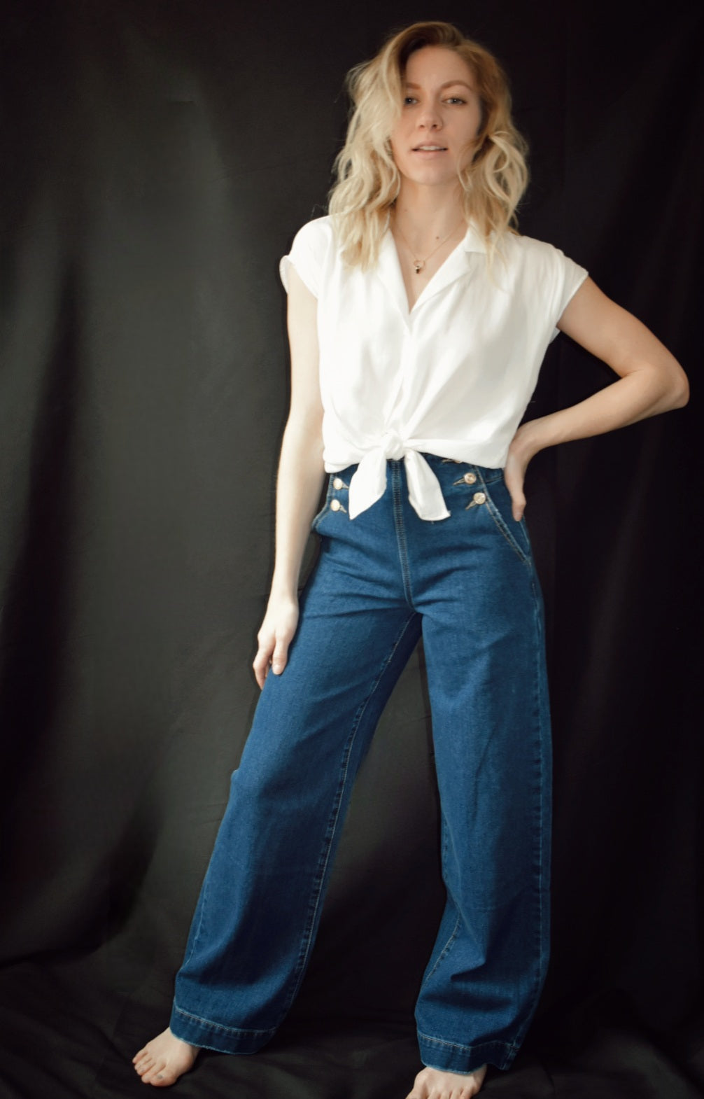 Q2. Relaxed high waist silhouette jeans with wide leg and straight fit. Gold sailor buttons on either side in the front. Dark blue. No holes no distressed wash. Made in Italy. 