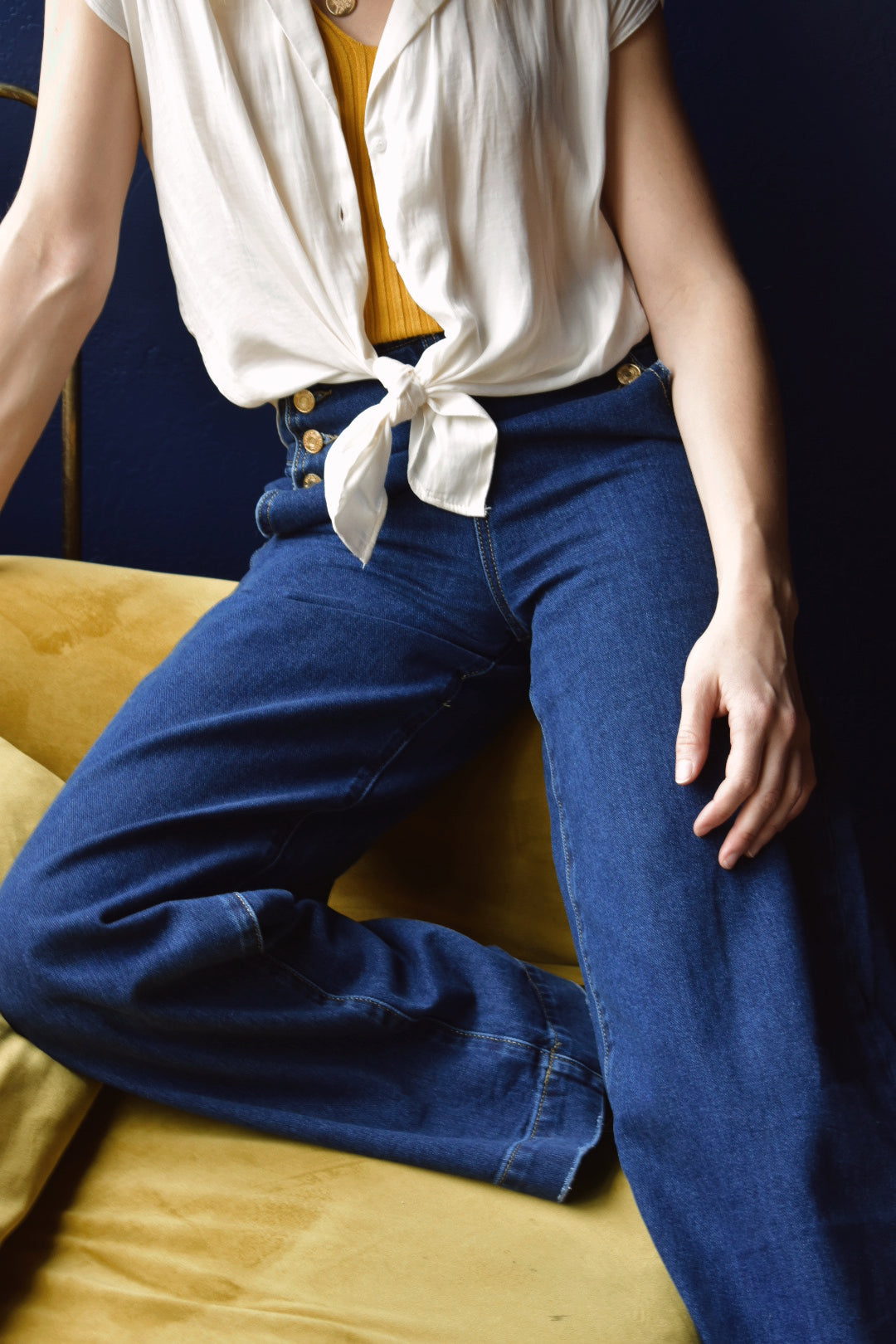 Q2. Relaxed high waist silhouette jeans with wide leg and straight fit. Gold sailor buttons on either side in the front. Dark blue. No holes no distressed wash. Made in Italy. 